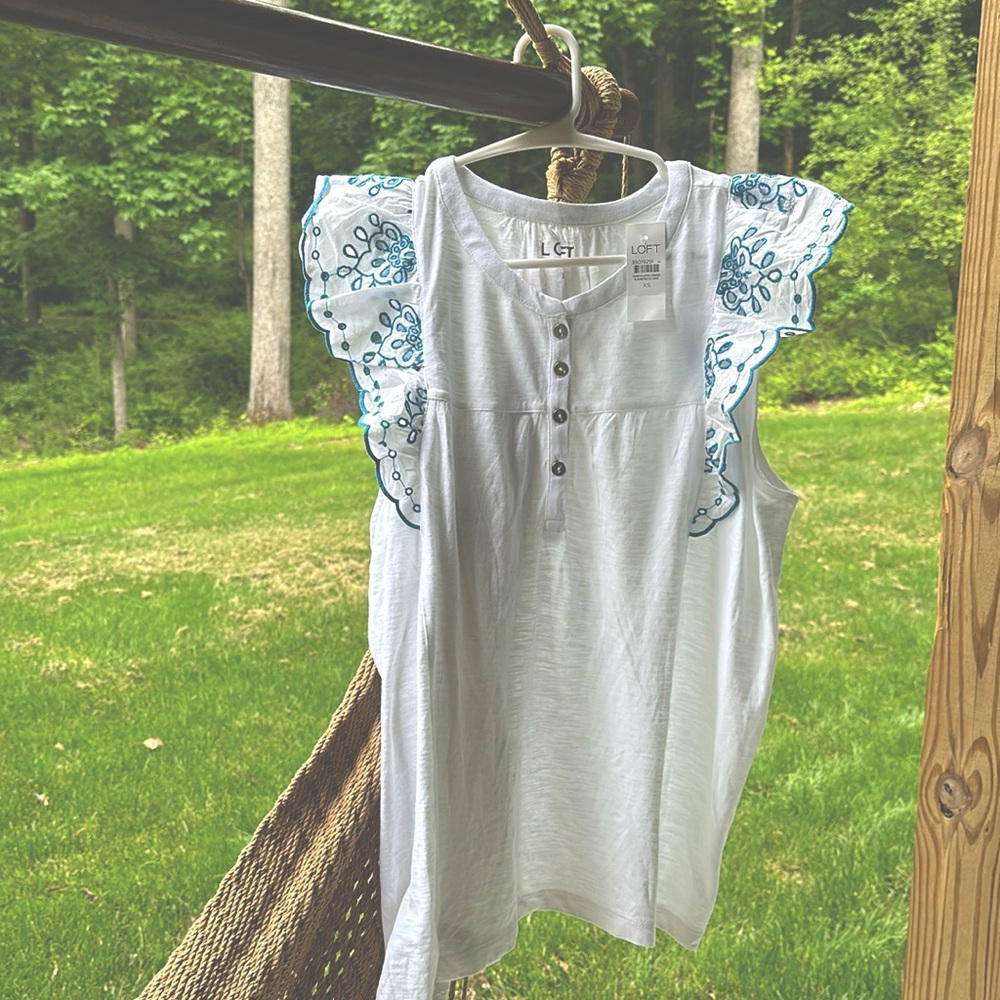 White capped sleeve tank with beautiful blue embroidered accents.